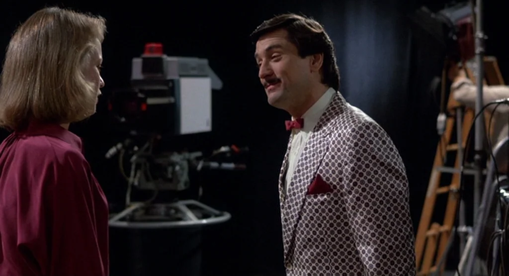 The King Of Comedy (1982) movie still: medium — A television studio background contains professional camera equipment and metallic lighting stands.…