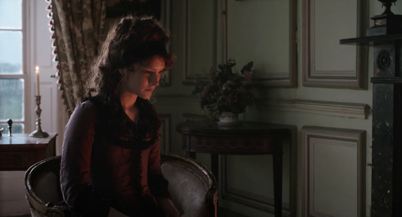 Love and Friendship (2016) movie still: medium — A nineteenth-century interior features pale green paneling and traditional decorative furniture. A…
