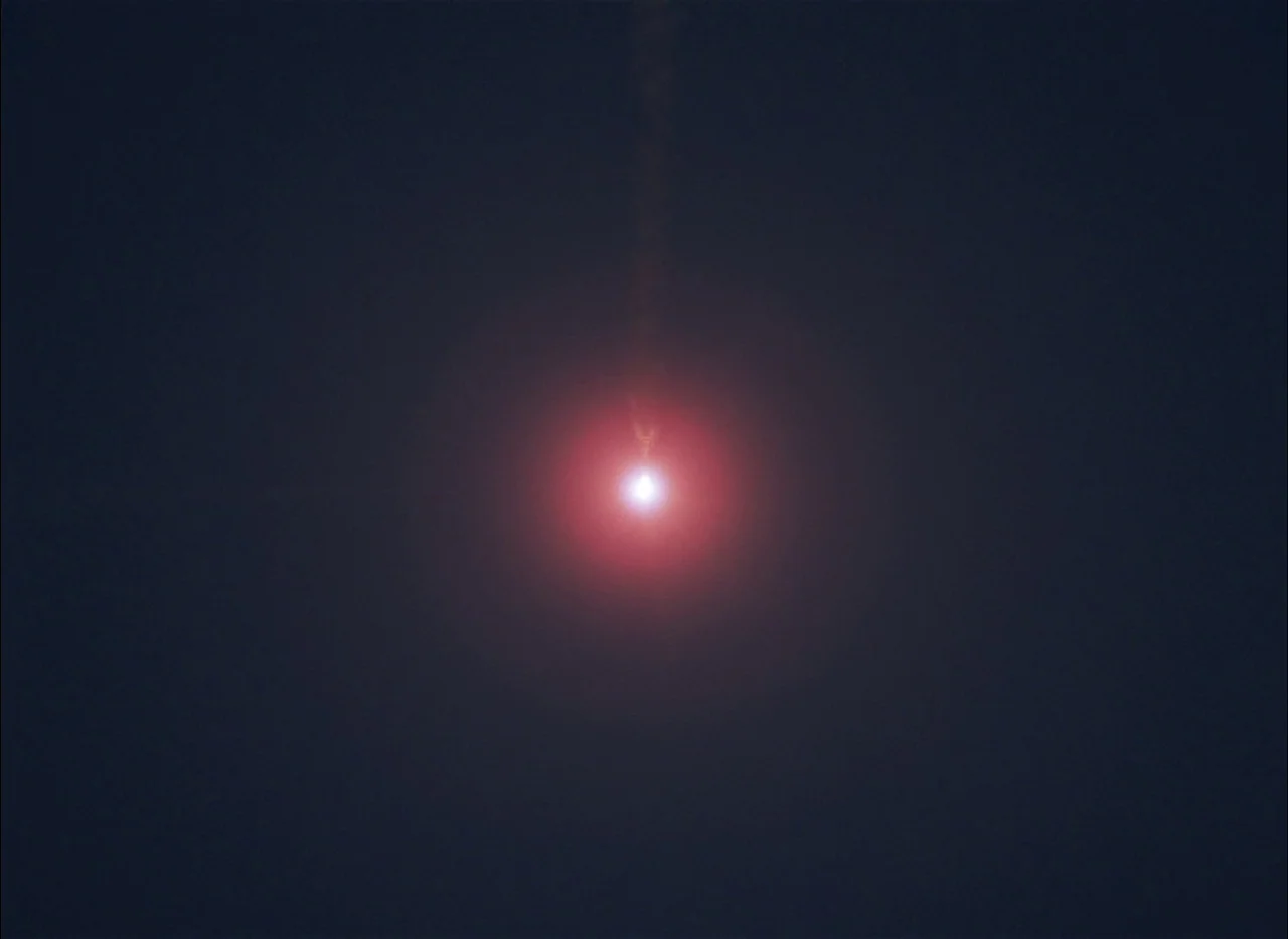 Come and See (1985) movie still: wide — A featureless dark void represents the night sky. A concentrated point of light glows with an intense red…