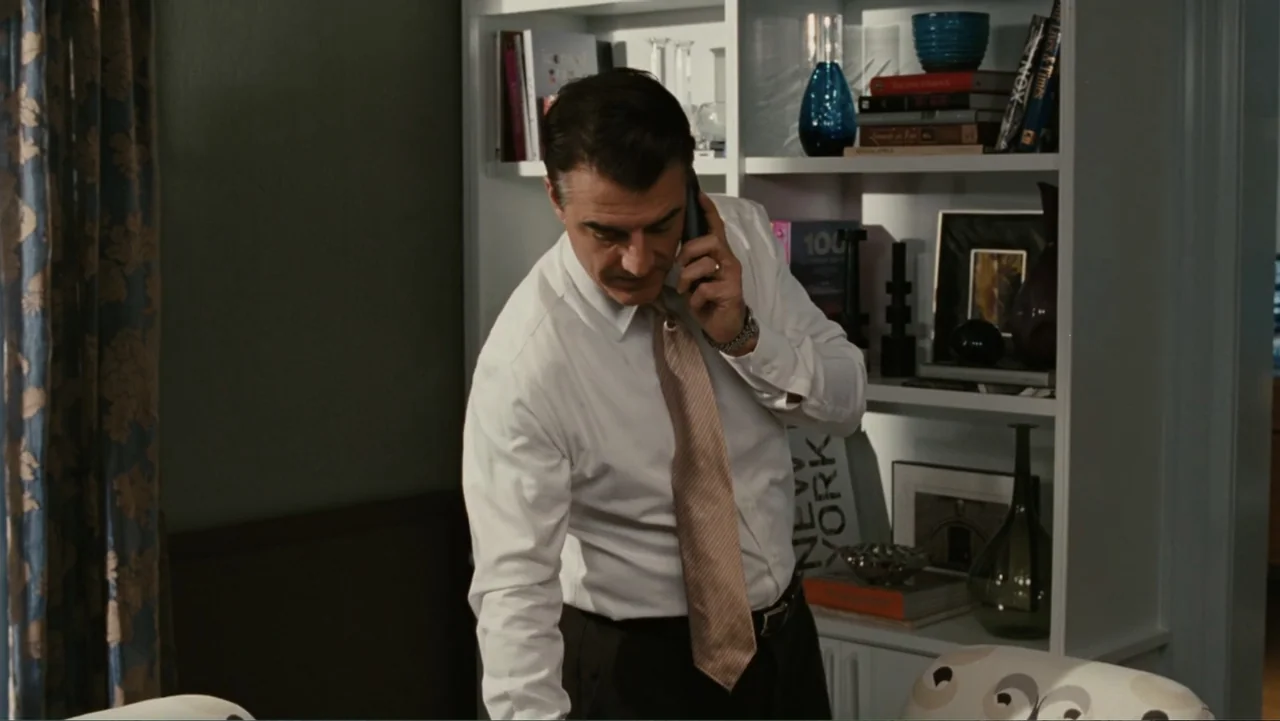 Sex and the City 2 (2010) movie still: medium — A home office interior features white built-in shelving filled with books and decorative vases. A…