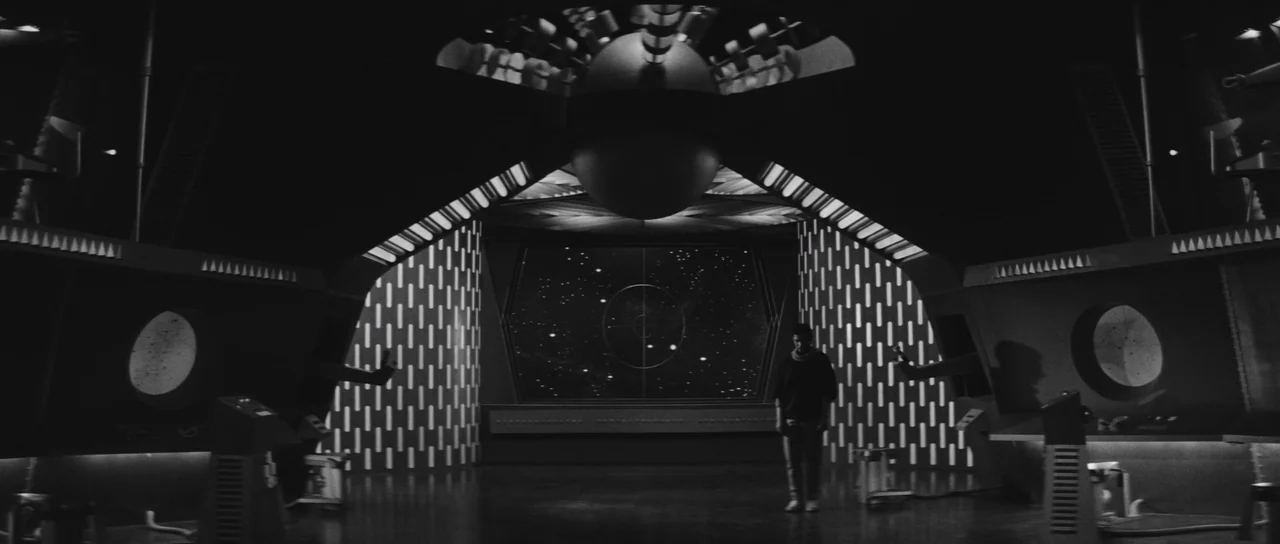 Ikarie XB 1 (1963) movie still: wide — A futuristic command center features a large central viewscreen showing a field of stars. A person stands in…