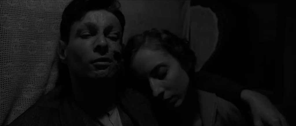 Frantz (2016) movie still: closeup — Two individuals lie together on a surface covered by a textured white lace blanket. The man has a visible…