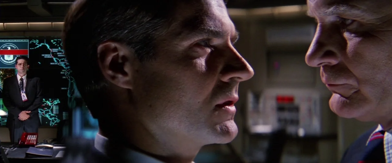 Mission: Impossible (1996) movie still: medium — A dark, high-tech command center features large wall-mounted maps with glowing blue data points.…