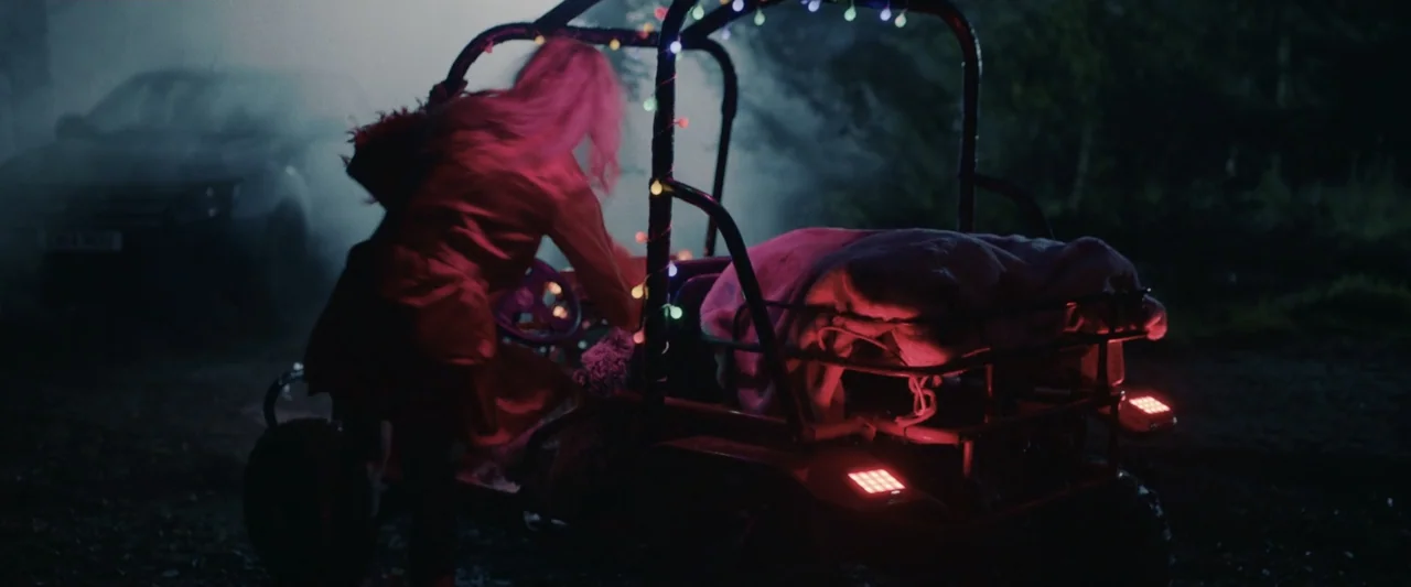 Winnie-the-Pooh: Blood and Honey 2 (2024) movie still: medium — A dark outdoor clearing is filled with smoke and deep shadows at night. A woman with…