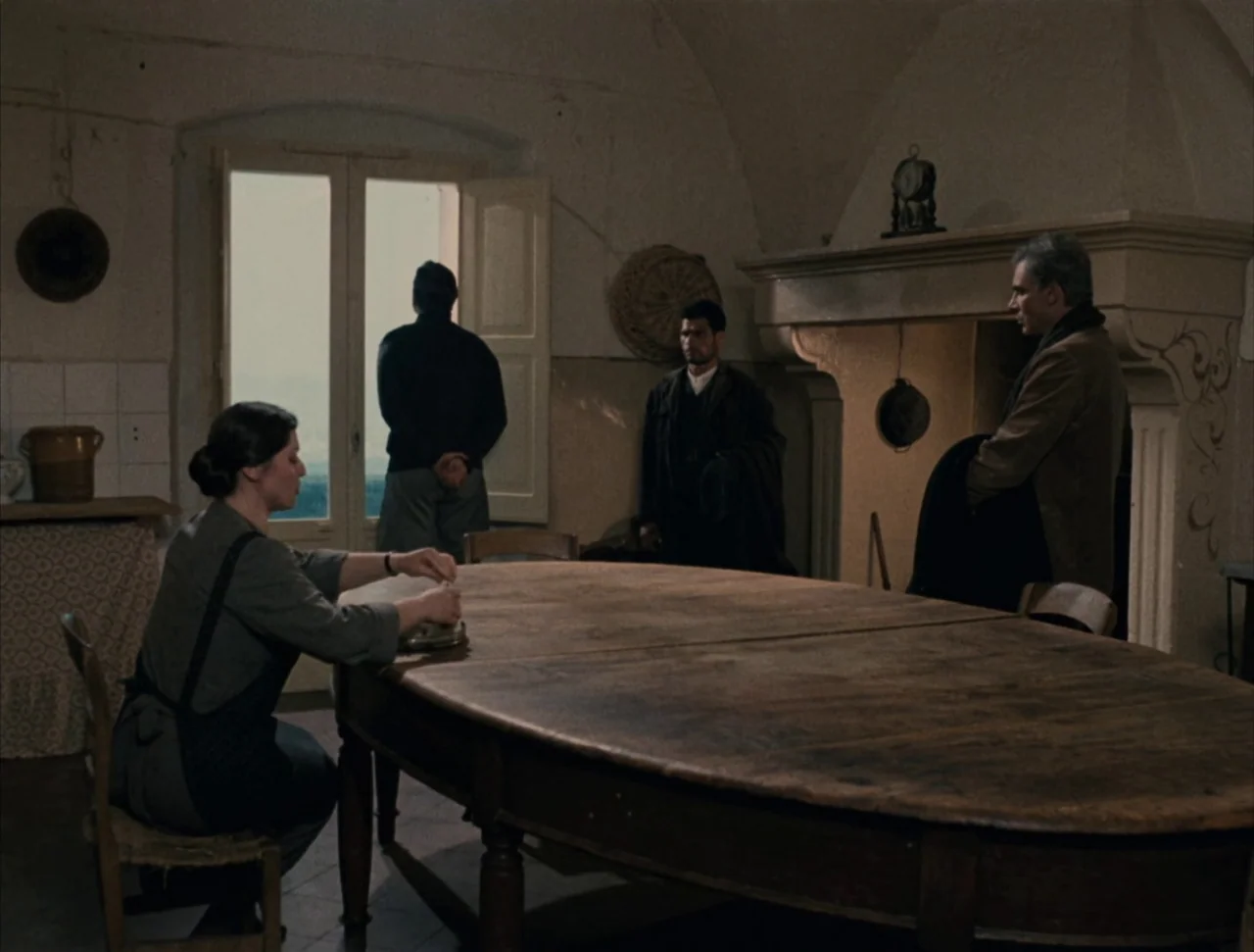 Christ Stopped at Eboli (1979) movie still: wide — A rustic dining room with high vaulted ceilings and a large wooden table. A woman works at the…