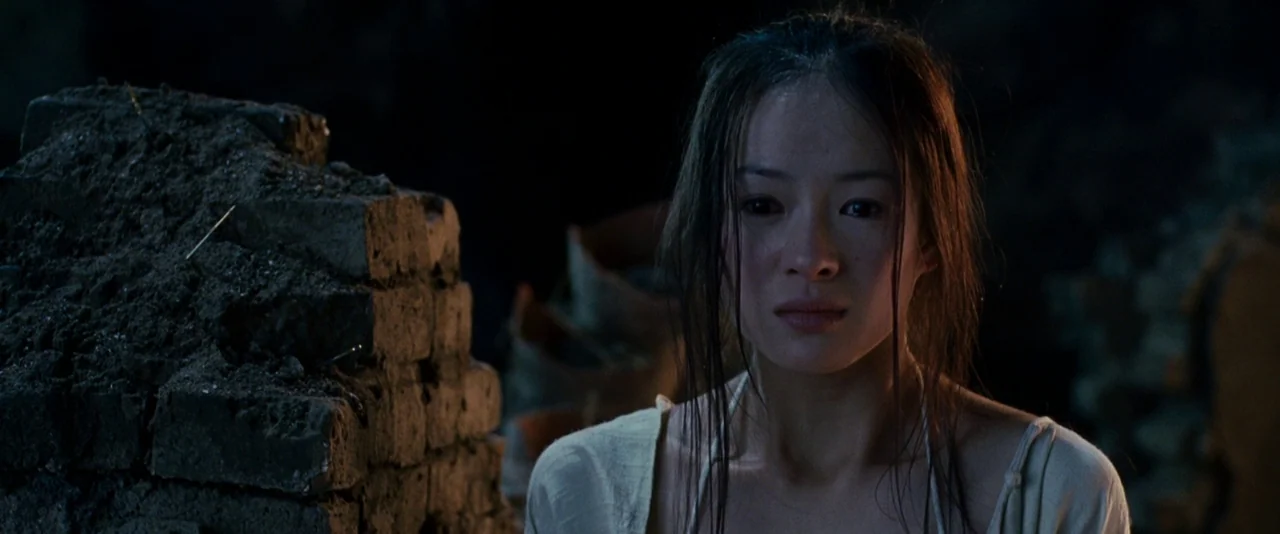 Crouching Tiger, Hidden Dragon (2000) movie still: medium — A dark, dimly lit stone-like interior with stacked brick elements. A woman with long…