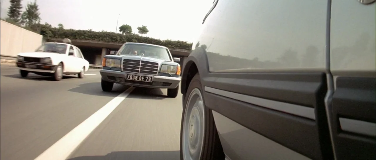 Subway (1985) movie still: wide — A high-speed shot from a low perspective on an open highway. Three vehicles travel in the same direction past a…