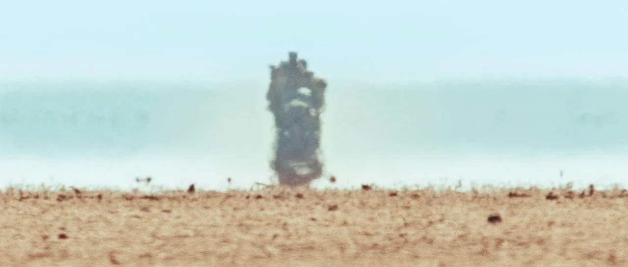 Australia (2008) movie still: wide — A vast, flat, and arid desert floor stretches toward a blurry, light blue horizon. A singular, distorted heat…