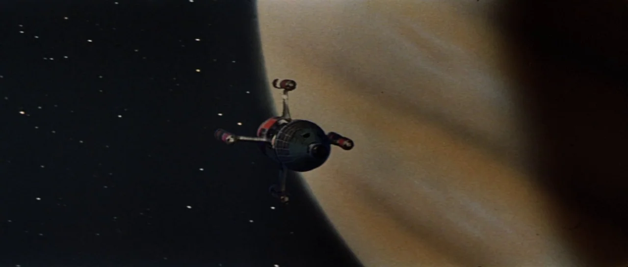 Invasion of Astro Monster (1965) movie still: wide — A small spherical spacecraft with protruding thruster arms floats against the backdrop of…
