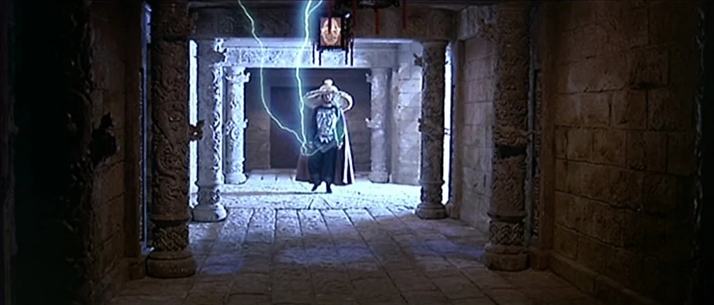 Big Trouble in Little China (1986) movie still: fullbody — An underground stone corridor is lined with intricately carved pillars and block masonry…
