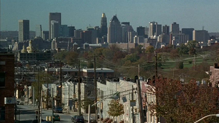 Making of: Castle Freak (1995) movie still: establishing — A view overlooking a city street with row houses leading toward a dense skyline. Autumn…