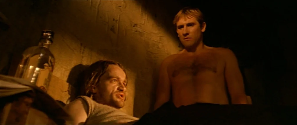 The Moon in the Gutter (1983) movie still: medium — A dimly lit, bare stone enclosure resembles a utilitarian living space with rough walls. One…