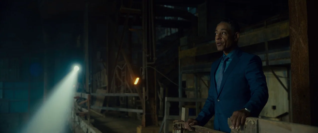Okja (2017) movie still: medium — A dark industrial structure features metal scaffolding and platforms obscured by deep, encroaching shadows. A man…