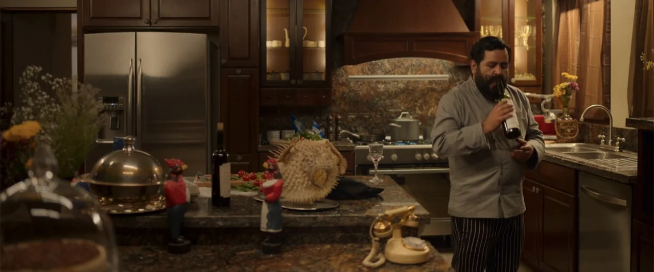 Tequila Re-Pasado (2023) movie still: medium — A well-appointed kitchen features dark wood cabinetry, granite countertops, and stainless steel…
