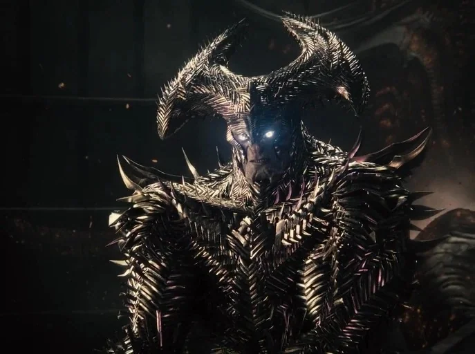 Zack Snyder's Justice League (2021) movie still: medium — A dark, textured environment surrounds a figure clad in complex, spiked metallic armor.…