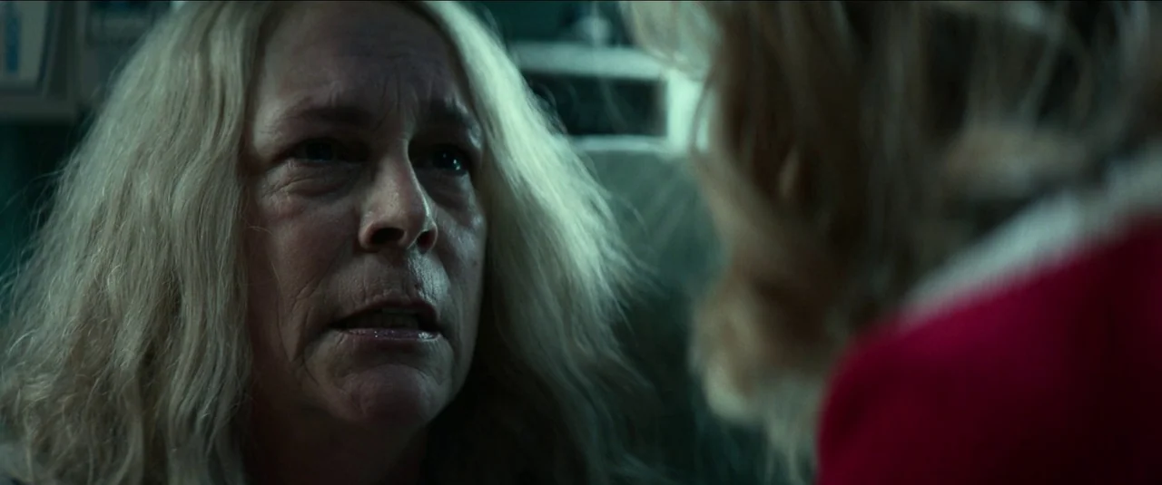 Halloween Kills (2021) movie still: closeup — A dimly lit hospital room with blurred, indistinct medical equipment visible in the background. An…
