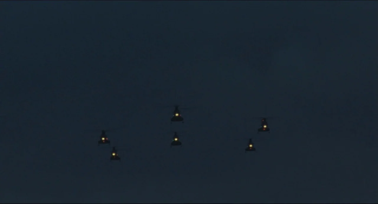 Godzilla vs. Biollante (1989) movie still: wide — A formation of five military helicopters is silhouetted against a dark, overcast night sky. Only…