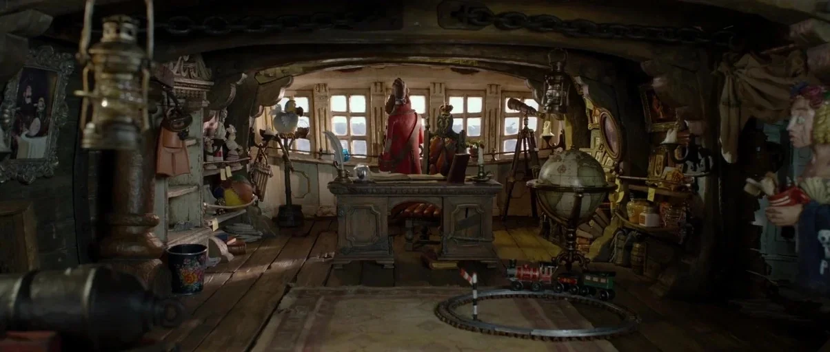 The Pirates! Band of Misfits (2012) movie still: wide — An interior space within a ship featuring wooden walls and a large desk. A man faces out…