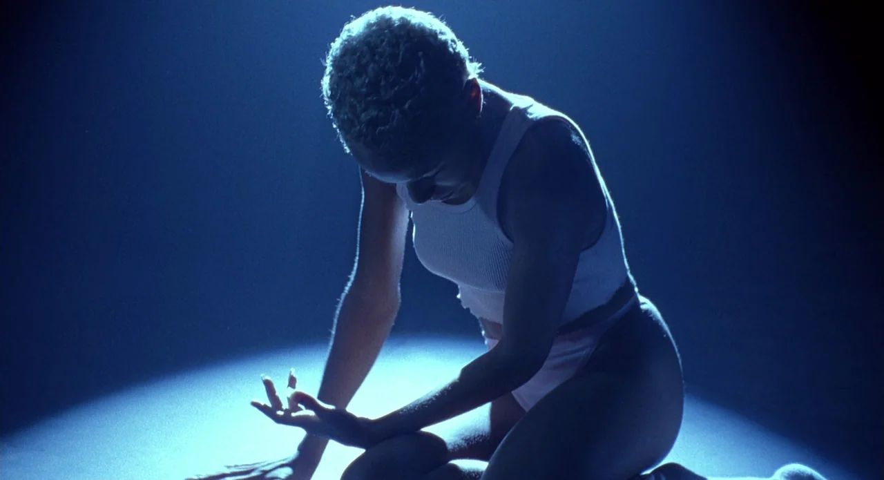 Tales from the Crypt: Demon Knight (1995) movie still: medium — A woman kneels in a tight circular beam of light on a dark floor. She looks down at…