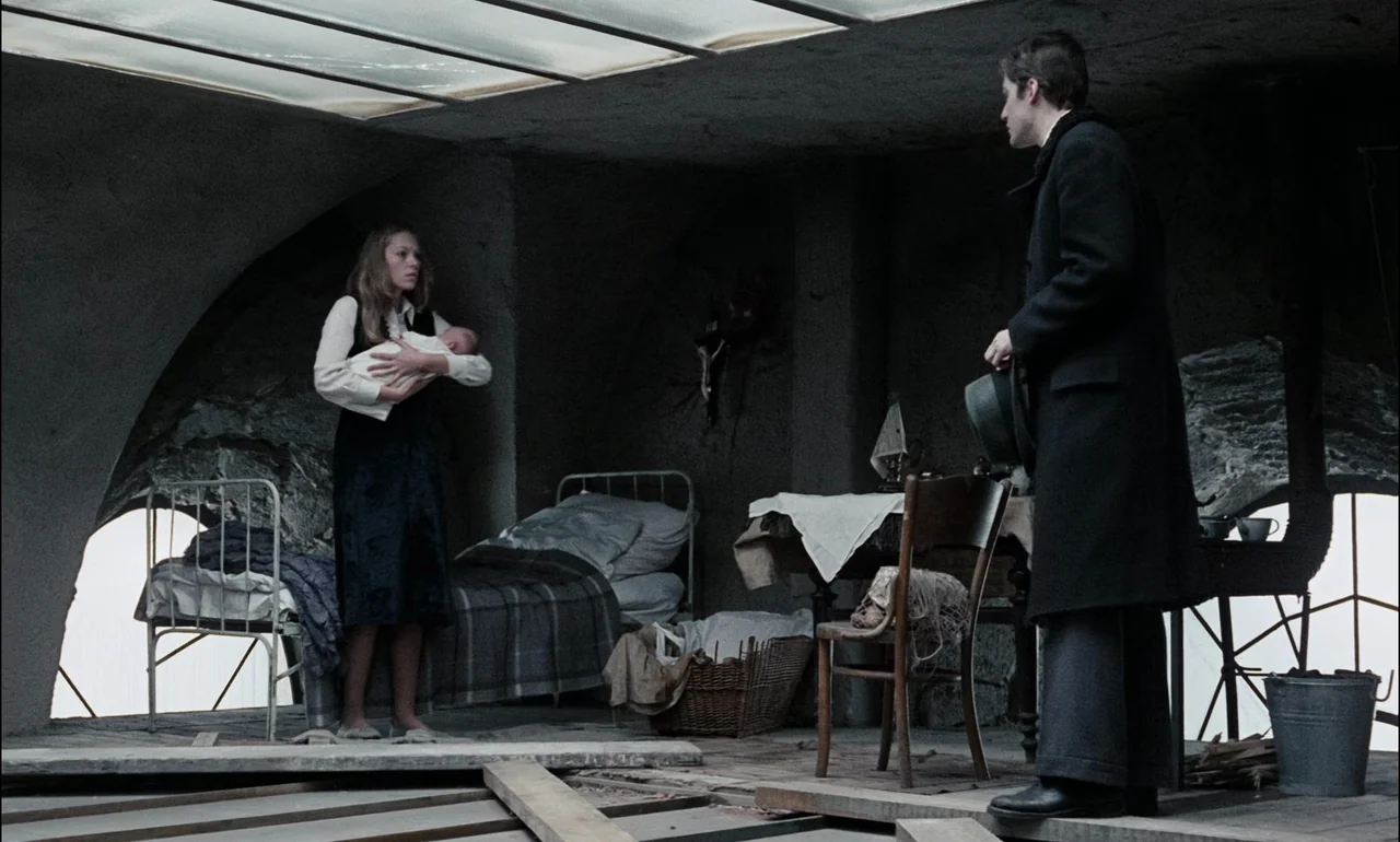 The Third Part of the Night (1971) movie still: wide — A stark, makeshift attic space features raw stone walls, a metal bed frame, and wooden planks…