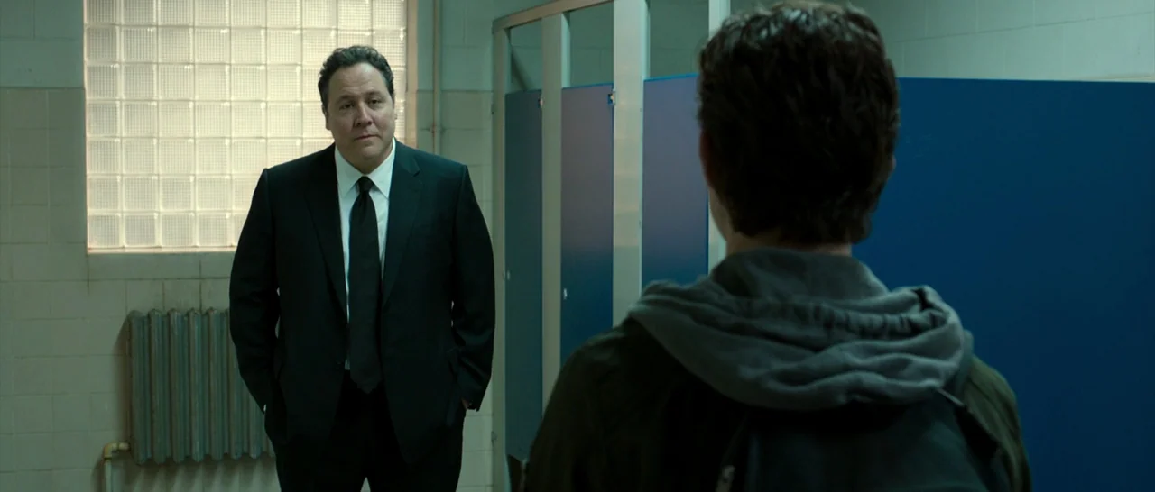 Spider Man: Homecoming (2017) movie still: medium — A utilitarian restroom features blue partitions and glass block windows against light-colored…