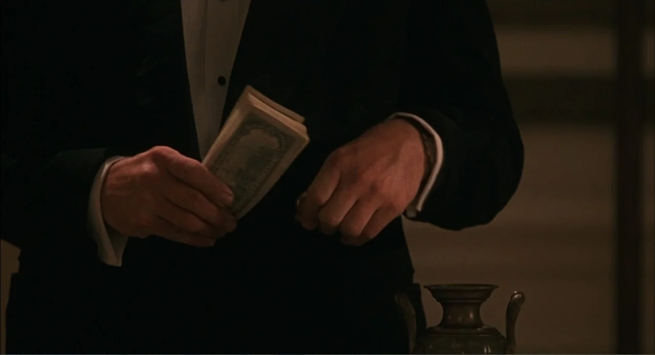 Wild Orchid II: Two Shades of Blue (1991) movie still: medium — A dimly lit interior space is visible in the background. A person in a formal black…