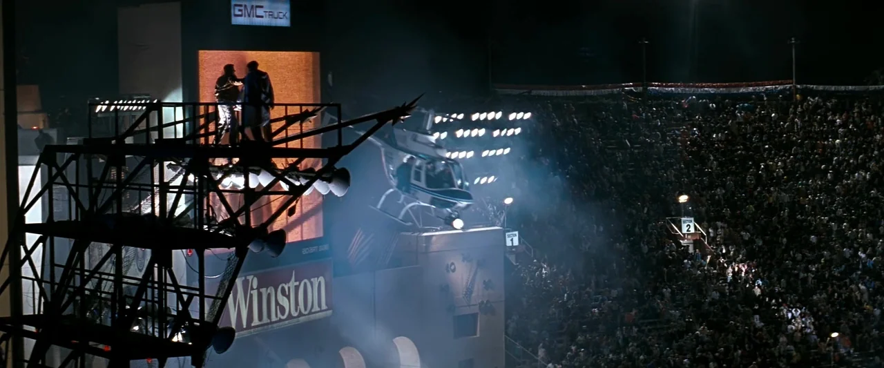 The Last Boy Scout (1991) movie still: wide — A high-angle view shows a stadium maintenance gantry positioned above packed seating areas. A…