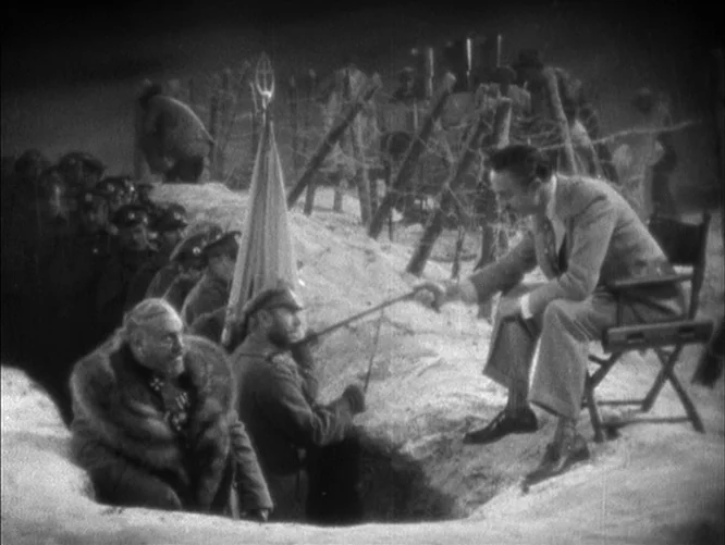 The Last Command (1928) movie still: wide — A snowy military trench with barbed wire obstacles lines a dirt embankment. A man in a suit hands a…