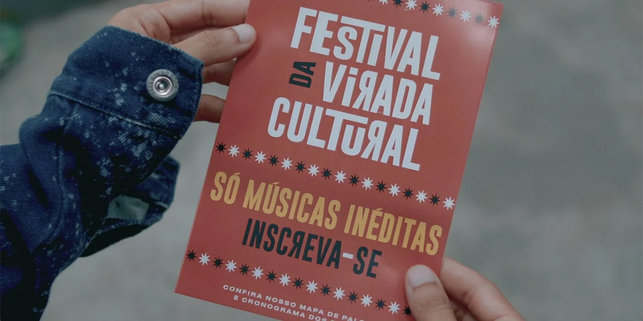 An Unforgettable Year - Autumn (2023) movie still: closeup — A close-up view of hands holding a red festival flyer with white typography. The flyer…