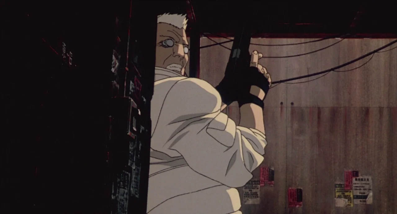 Ghost in the Shell (1995) movie still: medium — A dark urban alleyway features concrete walls plastered with weathered, peeling paper posters. An…