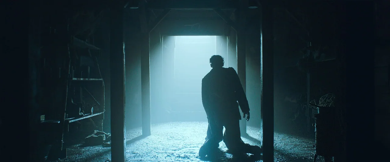 All Quiet on the Western Front (2022) movie still: medium — A dark, cramped space contains vertical wooden structural supports and rough, damp…