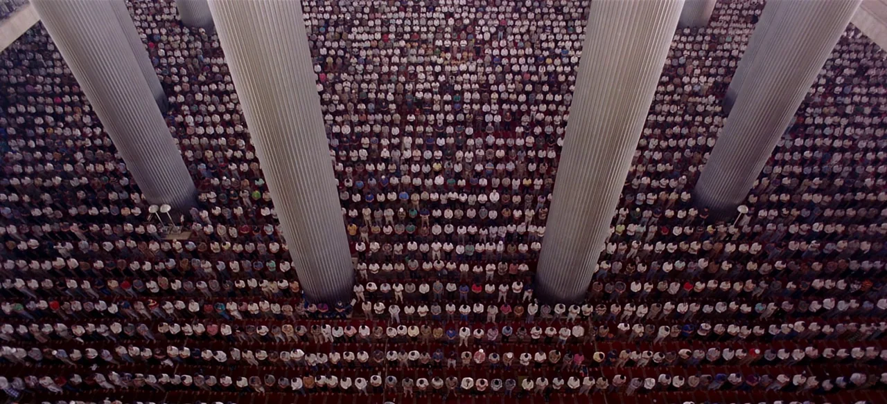 Baraka (1992) movie still: wide — A vast interior space of a mosque features many tall fluted pillars. Hundreds of men stand in neat, symmetrical…