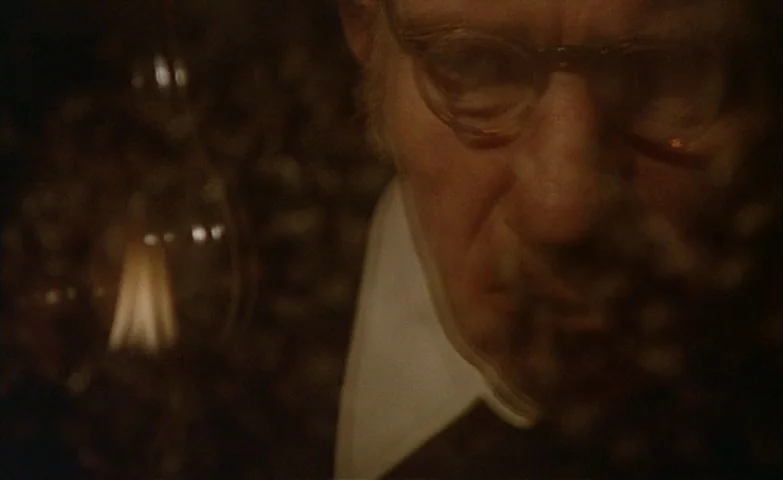 Spirit Of The Beehive (1973) movie still: closeup — A dark, dimly lit laboratory setting contains an old-fashioned glowing vacuum tube bulb. An…