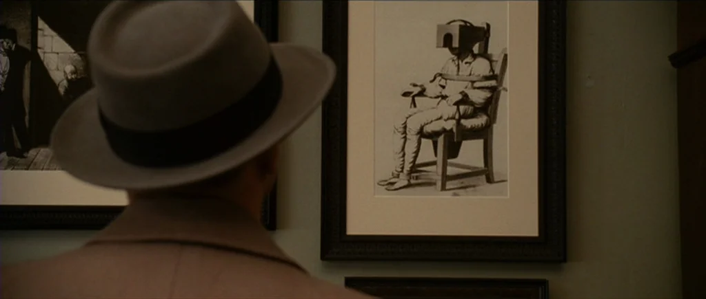 Shutter Island (2010) movie still: medium — A light-walled room features several framed black-and-white historical illustrations hanging…