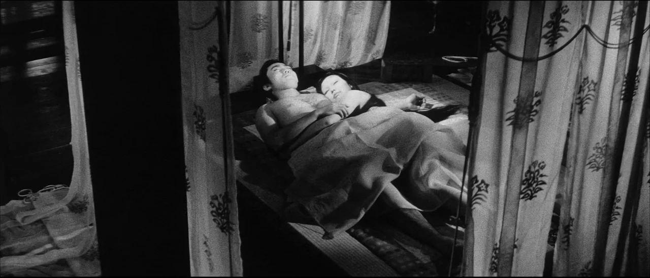 Kuroneko (1968) movie still: medium — A traditional Japanese room features patterned curtains partially obscuring the view of the floor. A man and…