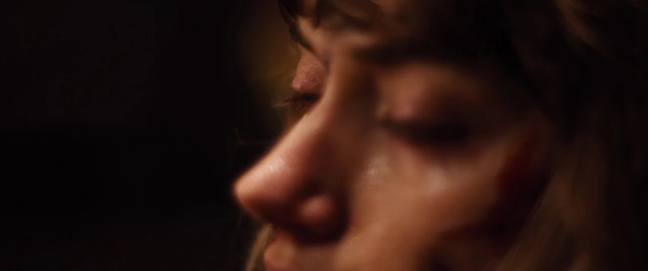 Black Christmas (2006) movie still: closeup — A close-up of a person's face in extreme low-light conditions with shallow focus. The woman has her…