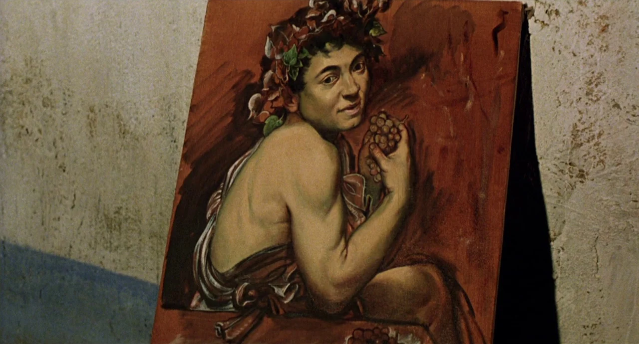 Caravaggio (1986) movie still: medium — A painting of a young man sits against a rough, textured plaster wall. The oil painting depicts a figure…