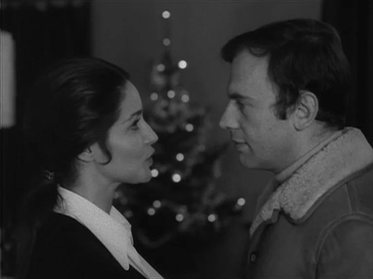 My Night At Maud’s (Ma Nuit Chez Maud) (1969) movie still: medium — A dimly lit interior space features a decorated Christmas tree blurred in the…