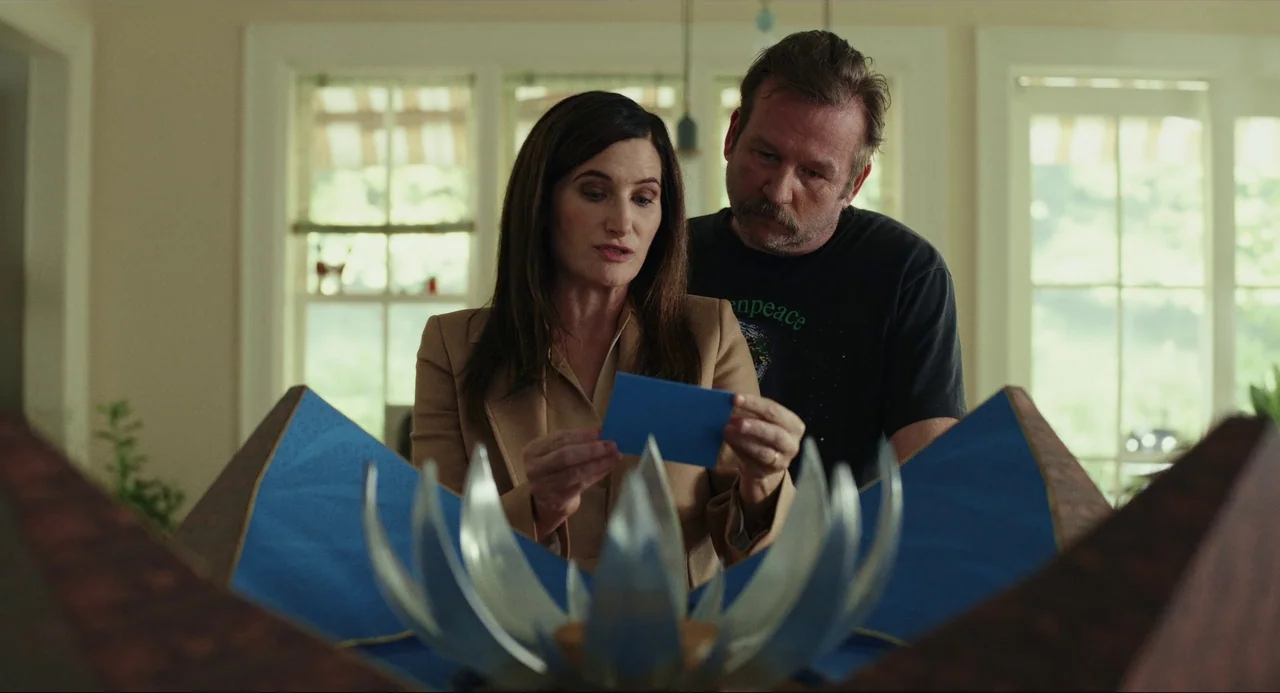 Glass Onion (2022) movie still: medium — A sunlit room features a pair of people standing over an ornate mechanical sculpture. They examine a small…