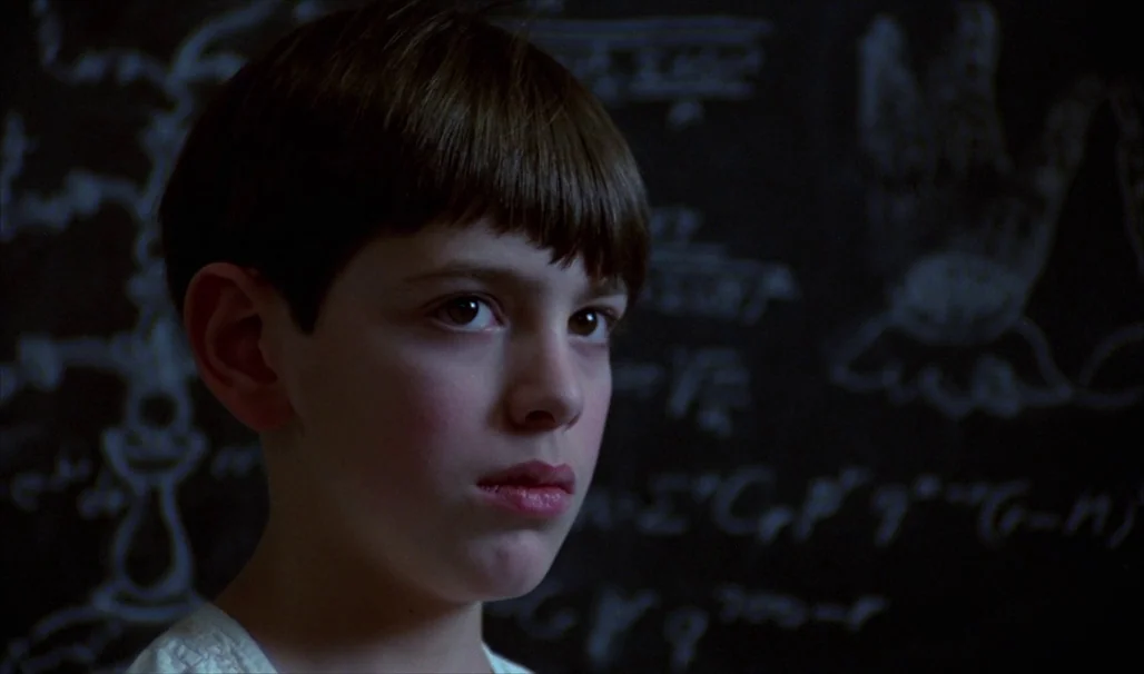 Fanny and Alexander (1982) movie still: closeup — A dimly lit room features a black chalkboard covered in complex handwritten mathematical…