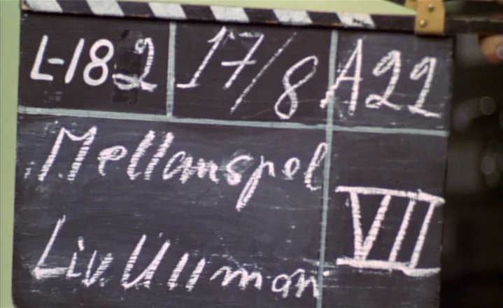 The Passion of Anna (1969) movie still: closeup — A close-up shot of a black film slate with white handwritten chalk text. The slate includes…