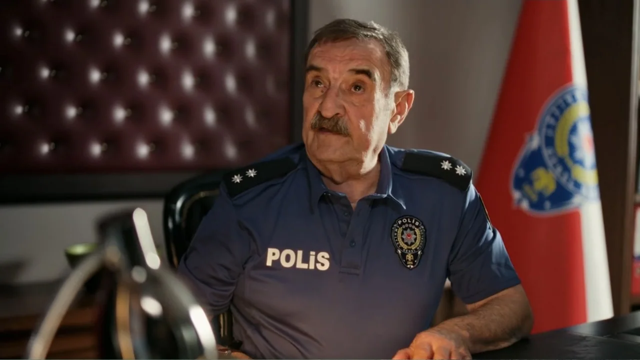 Paranormal Cuma (2024) movie still: medium — An office interior features a dark tufted leather wall and a Turkish police flag. An older police…