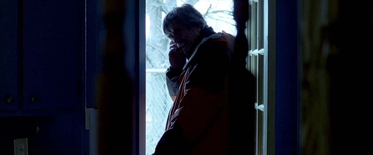 Ballast (2008) movie still: medium — An interior space features a dark doorway leading to a bright exterior. An older man stands within the doorway…