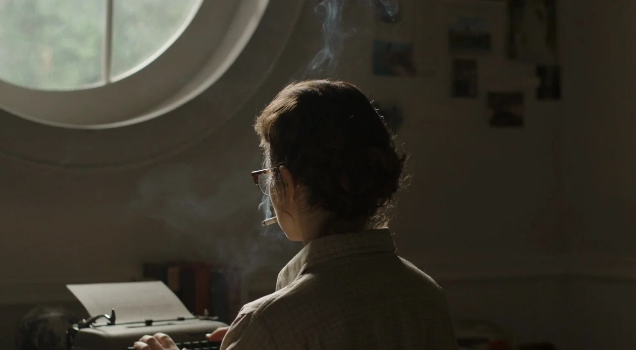 I Am The Pretty Thing That Lives In The House (2016) movie still: medium — A dimly lit study contains a manual typewriter positioned before a large…