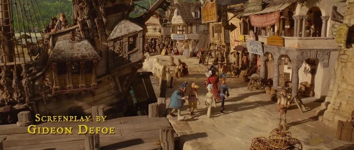 The Pirates! Band of Misfits (2012) movie still: wide — A miniature coastal town with weathered wooden structures and a large ship at anchor.…
