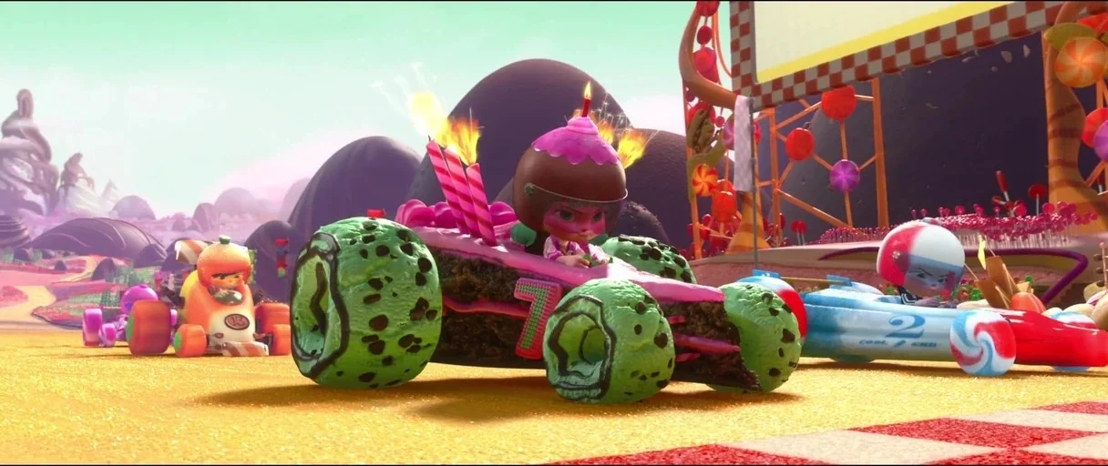 Wreck-It Ralph (2012) movie still: wide — A candy-themed racing track features colorful, food-shaped go-karts staged for competition. Several…