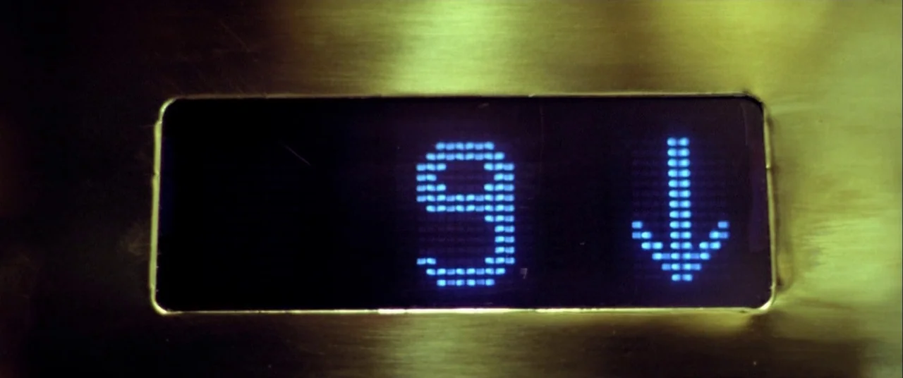 The Cooler (2003) movie still: closeup — A polished metallic surface contains a small rectangular digital indicator. The screen displays the number…