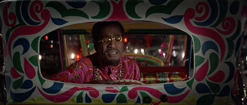Sweet Charity (1969) movie still: medium — A man sits inside a cabin painted with intricate, swirling psychedelic patterns. The interior is dark,…