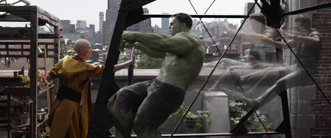 Avengers: Endgame (2019) movie still: wide — A rooftop terrace overlooking an urban skyline with brick textures and metal supports. A bald robed…