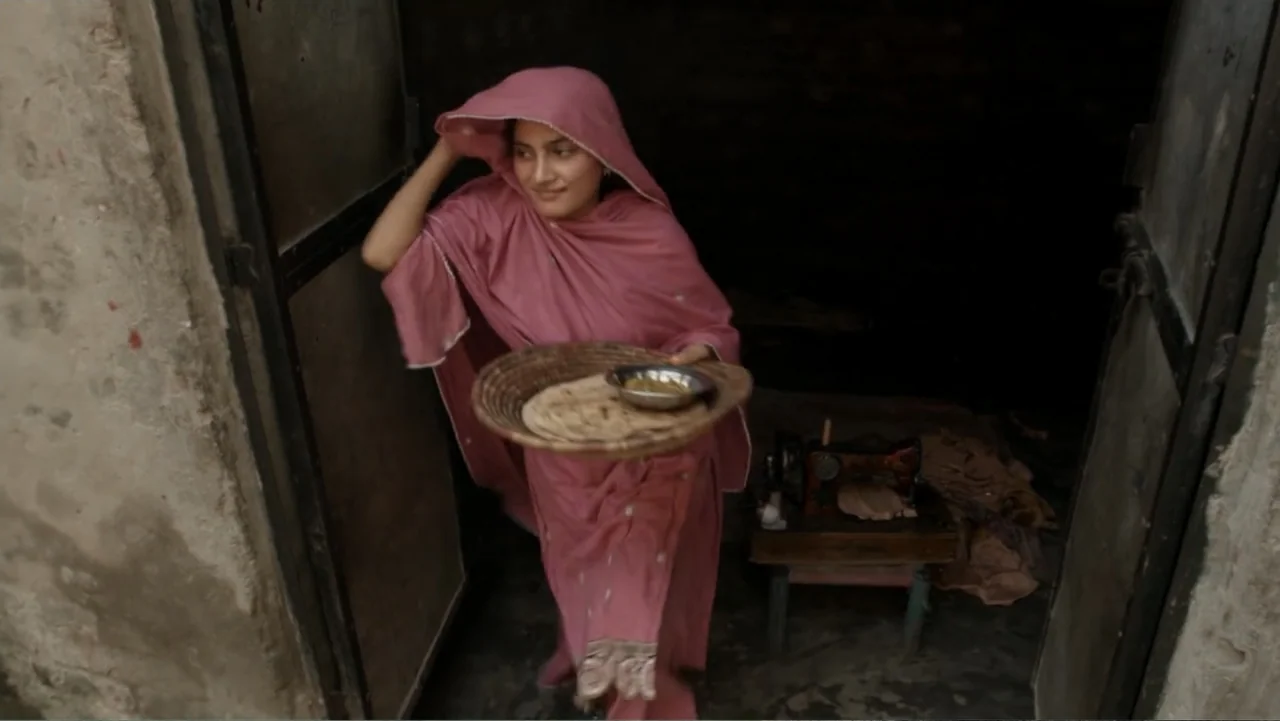 A Girl in the River: The Price of Forgiveness (2015) movie still: medium — A dimly lit room with distressed plaster walls and a sewing machine in…